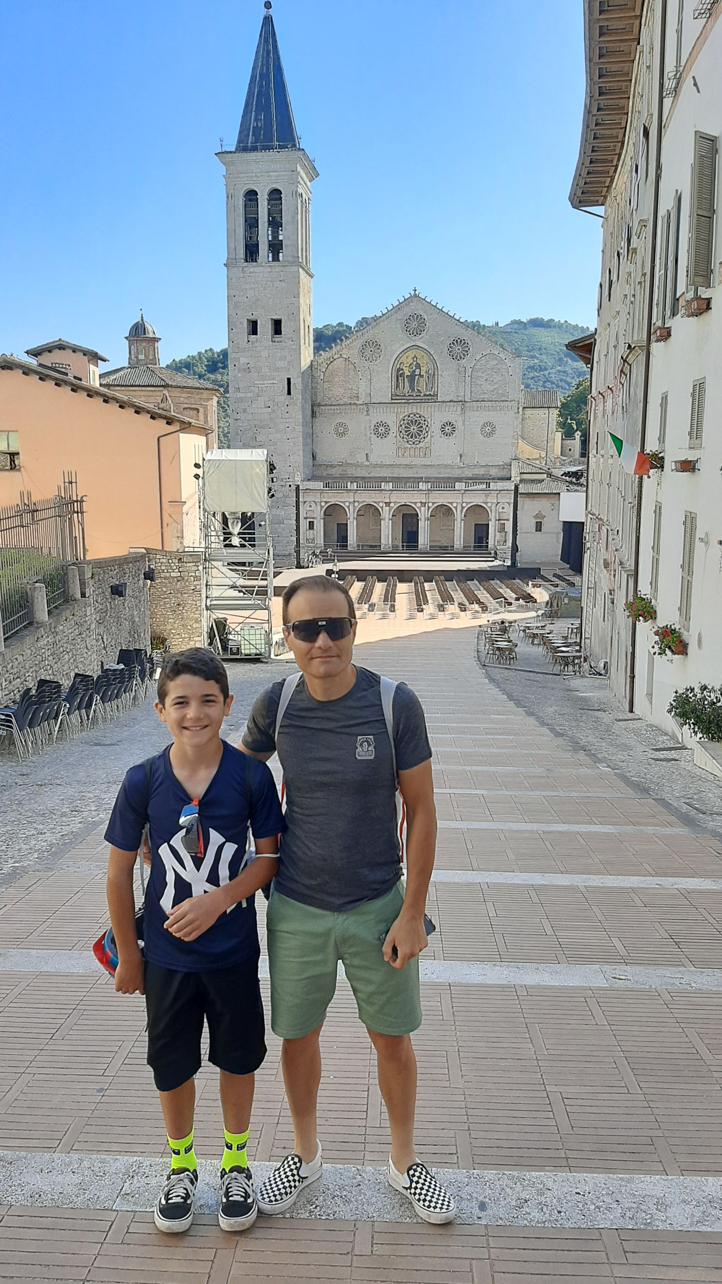 Coppia di turisti che passeggiano in una piazza storica di Assisi, Umbria